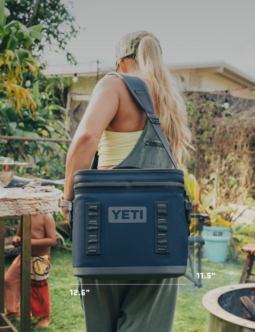 Person carrying a YETI cooler bag outdoors