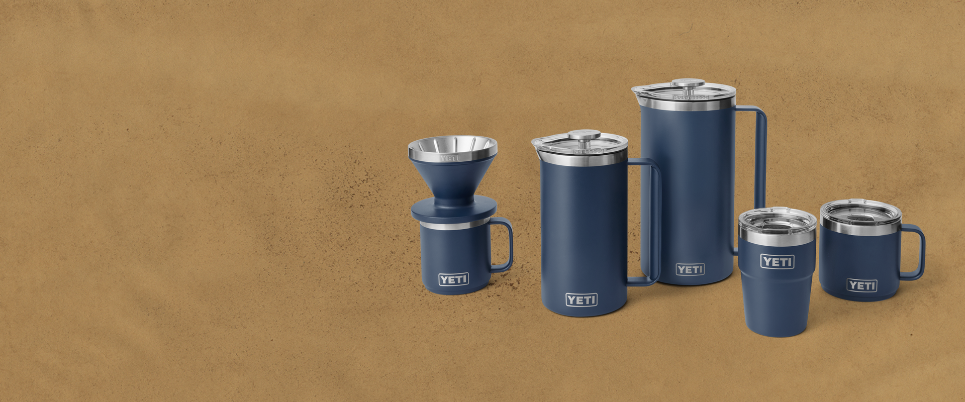 Set of blue YETI insulated mugs and containers on a brown background