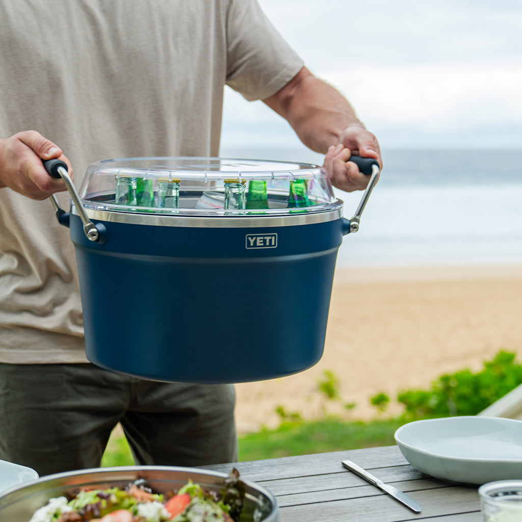 Person holding a blue YETI Beverage Tub with drinks outdoors