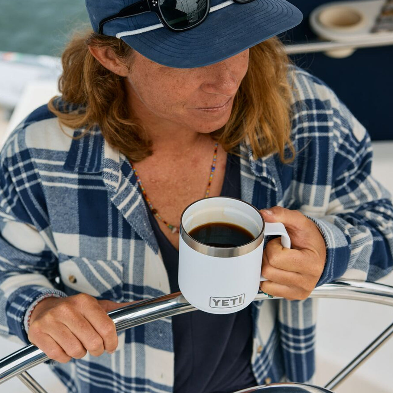 Person holding a YETI mug on a boat