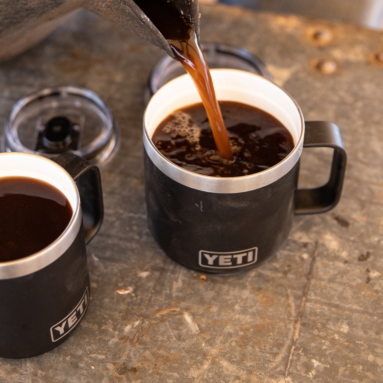 YETI mug being filled with coffee on a rustic surface