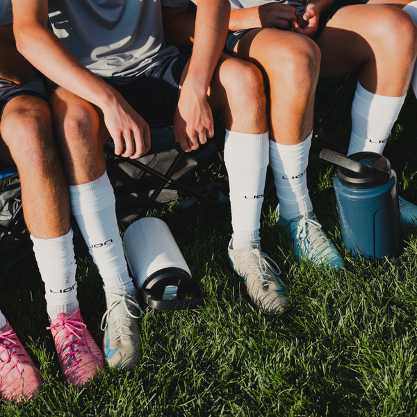 Football players sitting on a bench with Yeti Silo Jugs.