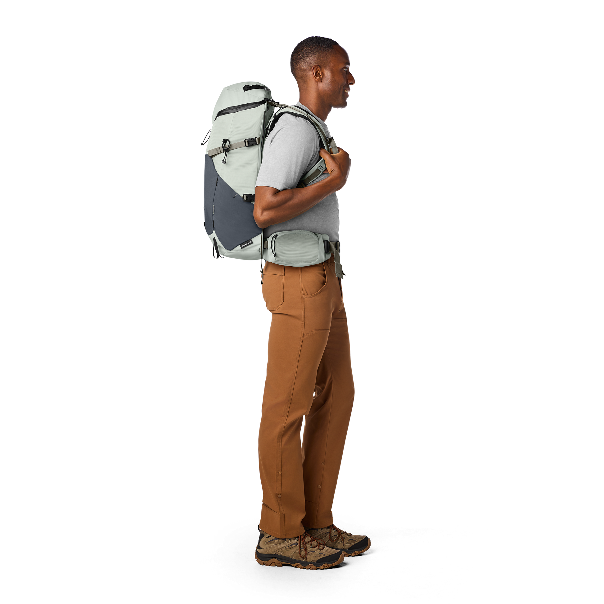 Man wearing a large backpack on a white background