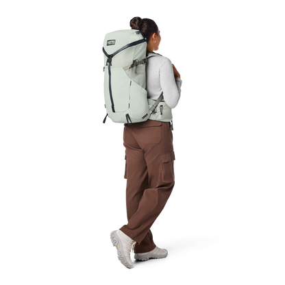 Person wearing a large backpack with a white background