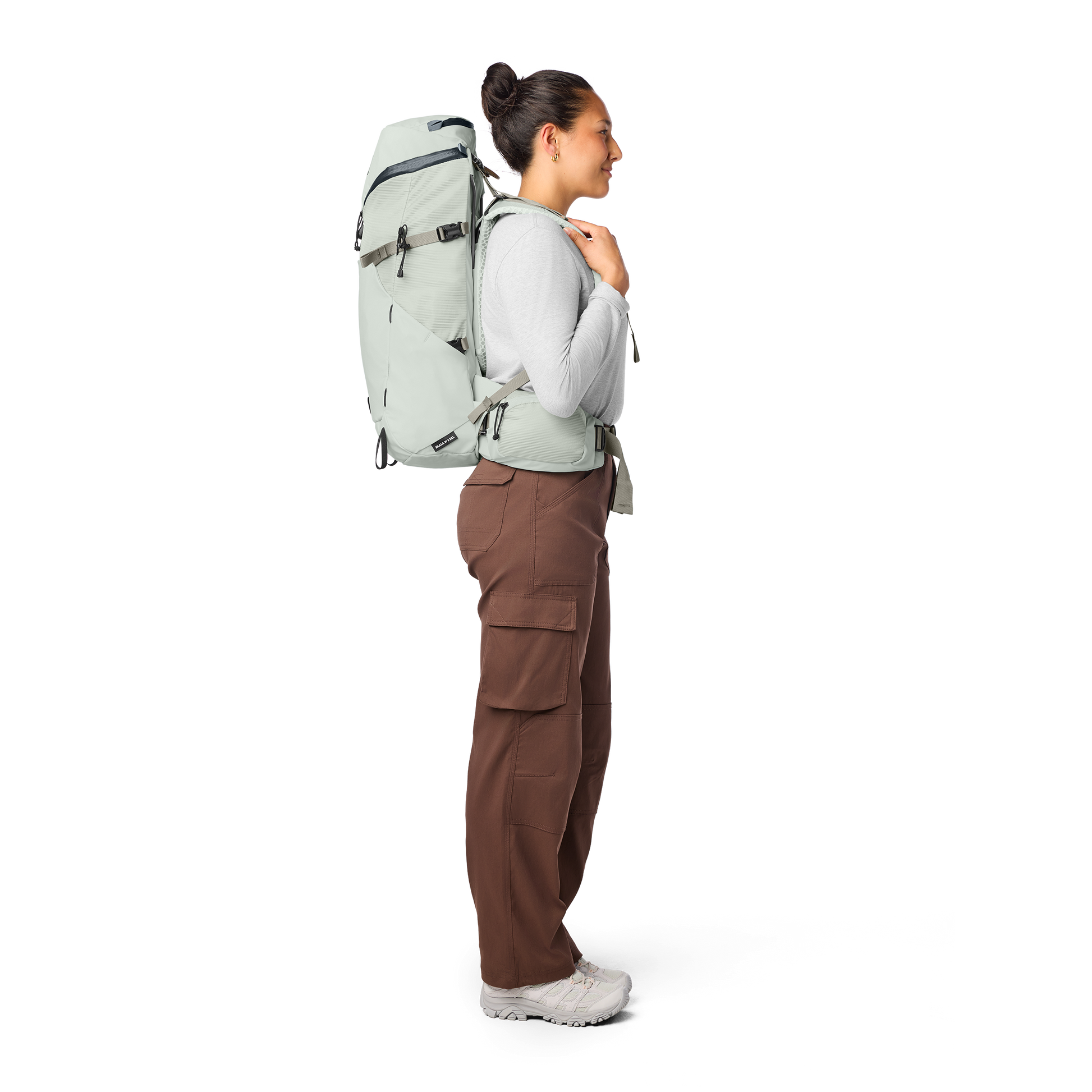 Person wearing a large green backpack on a white background