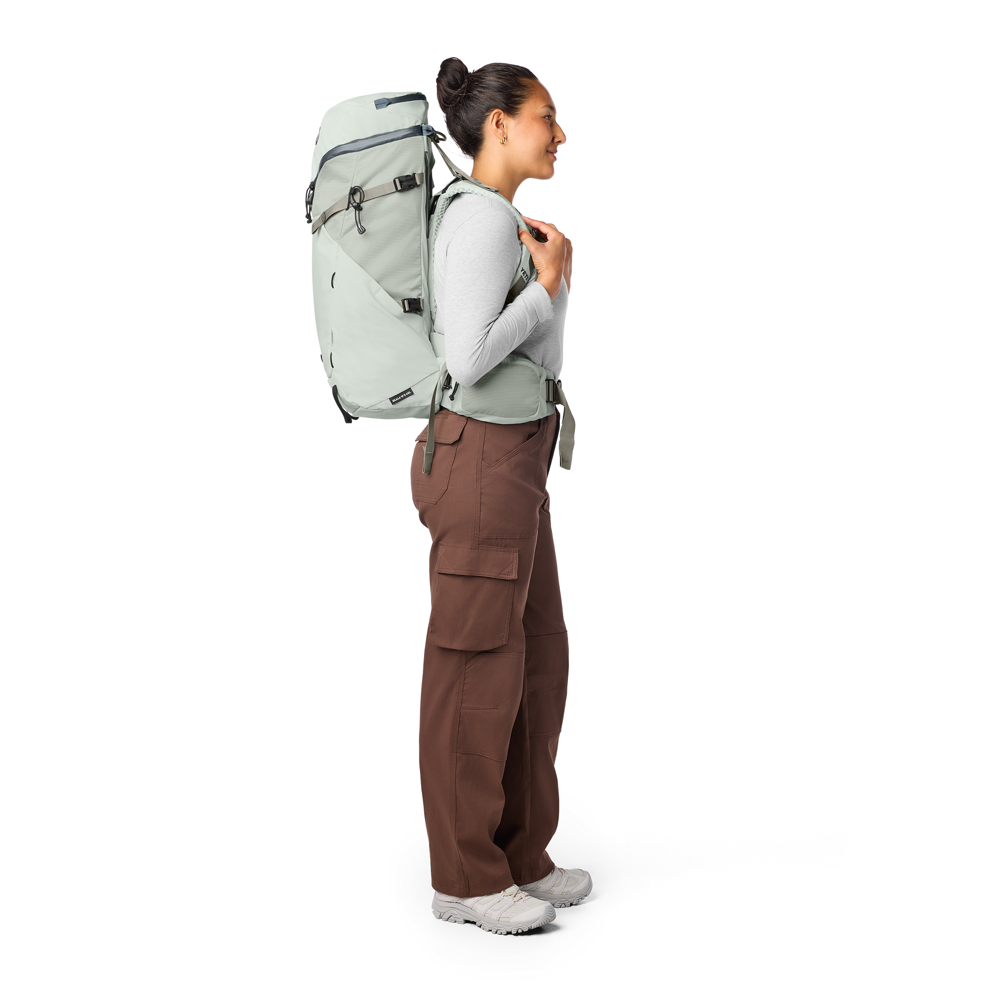 Person wearing a large white backpack on a white background